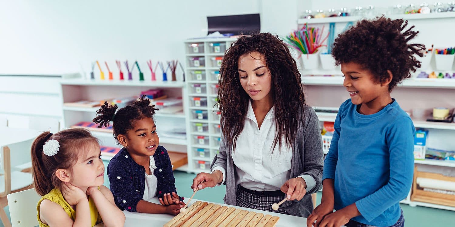 A teacher working with young children in a classroom